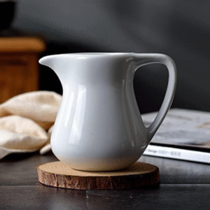White porcelain ceramic milk jug for coffee and tea
