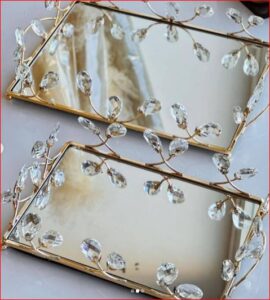 Gold toned mirrored serving tray with leaf-patterned edge