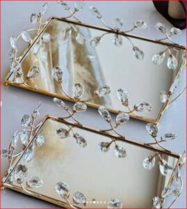 Gold toned mirrored serving tray with leaf-patterned edge